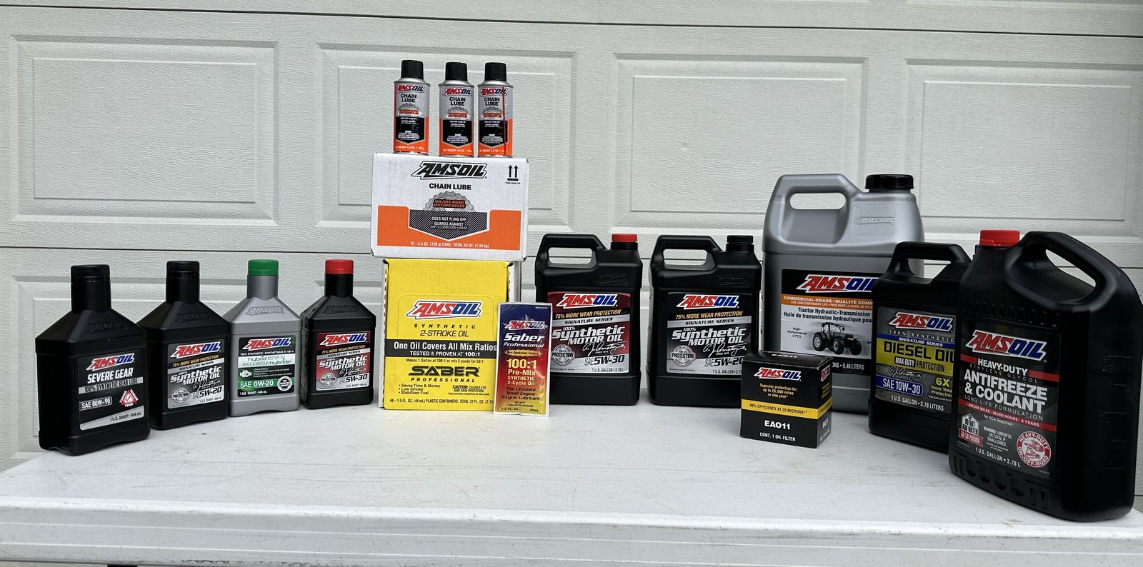 AMSOIL products: Signature Series motor oils, Max-Duty diesel oil, Severe Gear, Saber Professional 2-stroke oil, tractor hydraulic oil, antifreeze, chain lube and an Ea oil filter